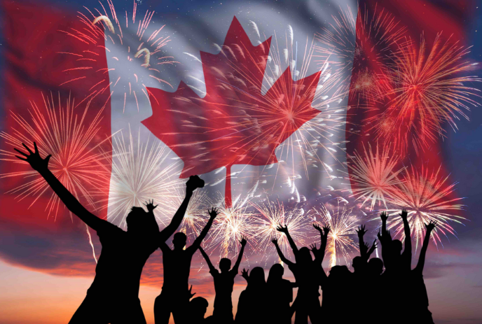 People celebrating fireworks with a Canadian flag in the background.