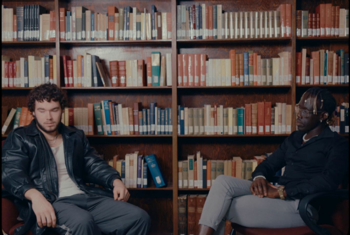 Two people sitting together inside of a library.