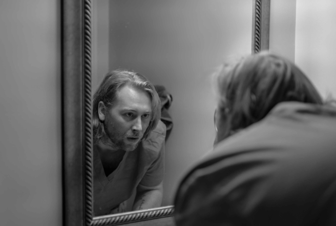 Person looking at themselves with concern in a mirror.