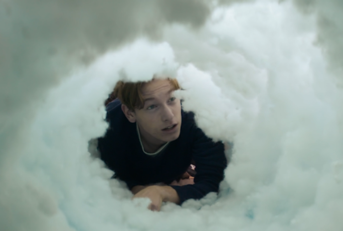 Person looking into an open area of a snowbank.