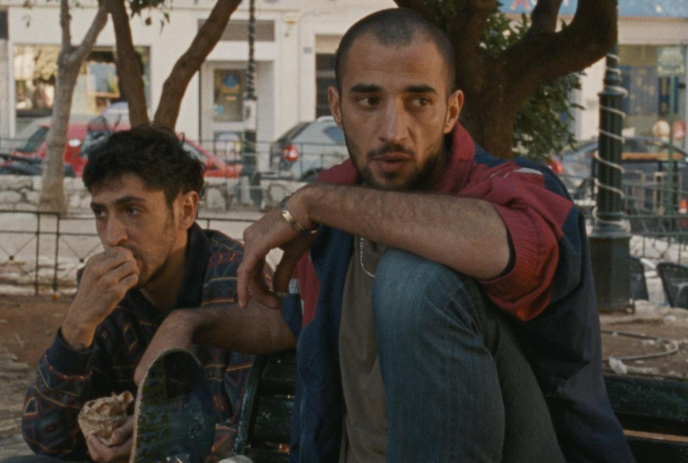 Two people sitting in a park looking troubled.