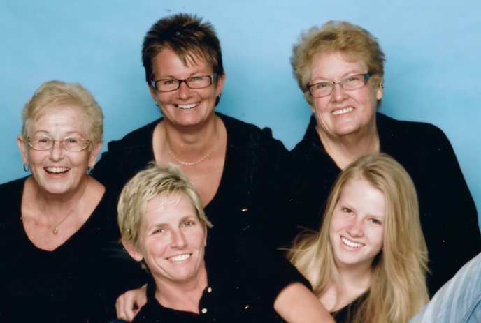 Multi-generational family photo with a blue background.