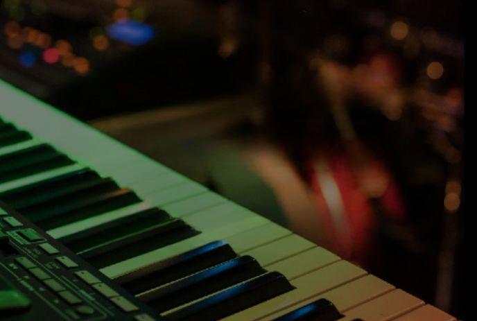 Close-up of electronic keyboard keys with a softly blurred background, highlighting the instrument’s details.