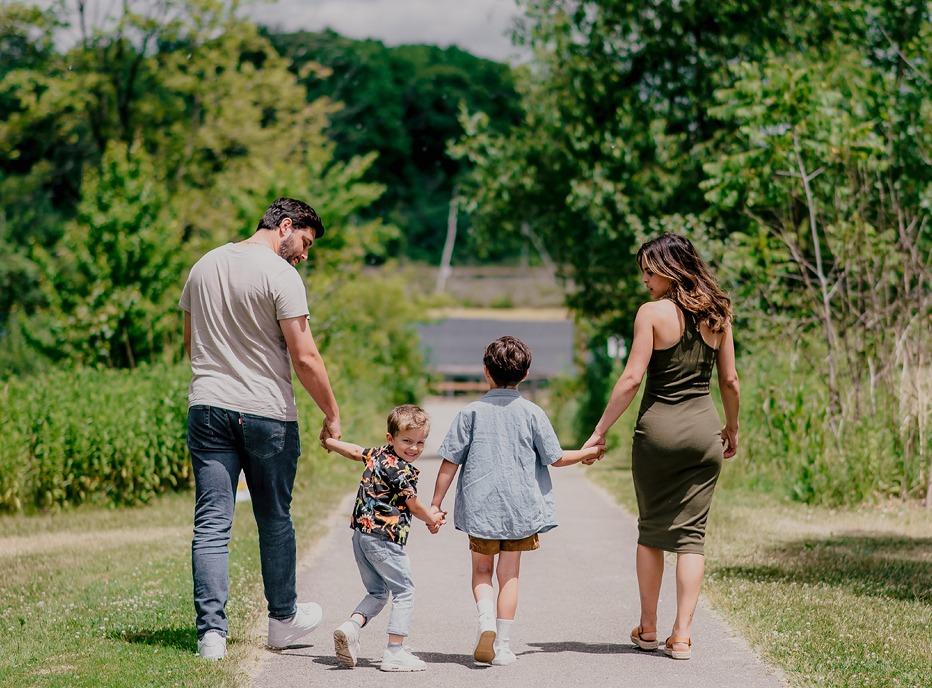 A family walking down a path surrounded by trees in London, Ontario