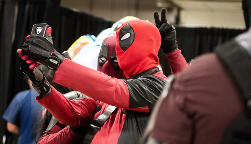 Two Comic Con attendees dressed up as Deadpool taking a selfie