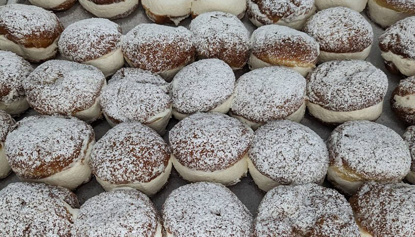 Freshly made cream puffs covered in powered sugar