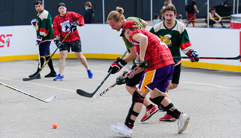 Competitive road hockey players fighting for the ball