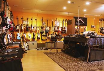 Various guitars hanging on walls on display at Music City Canada located in London, Ontario