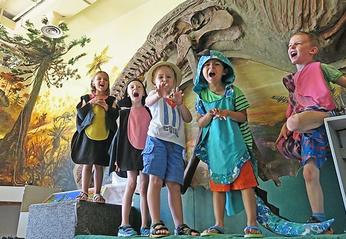 A small group of young kids dressed up like dinosaurs at The London Children's Museum located in