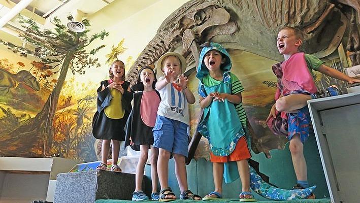 A small group of young kids dressed up like dinosaurs at The London Children's Museum located in